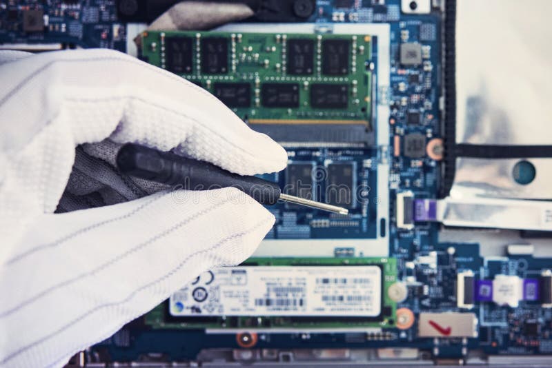 Replacement of memory in the laptop, in one of the service centers for repair of laptops. hand in a white glove holds a screwdrive