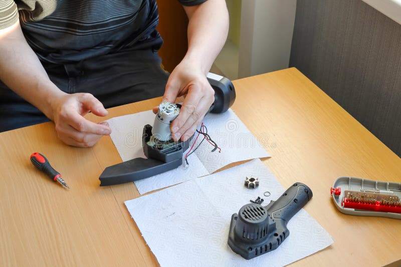 Replacing Electric Engine in Chain Saw, Disassembled Tool, Hands Work