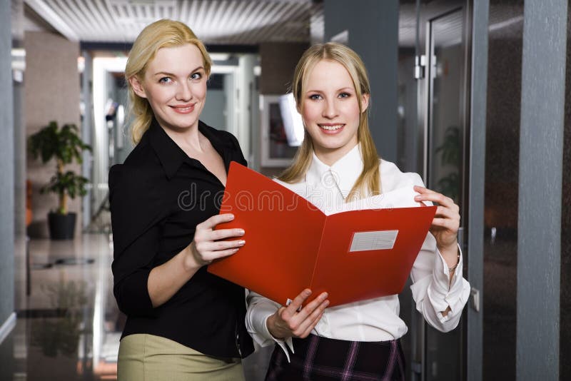 Two businesswomen are reading the report standing in the office. Standing file folder stock images, royalty-free photos and pictures