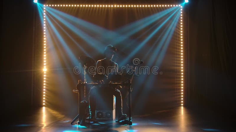 Representación en solitario de un tamborilero músico en un estudio oscuro en los rayos de luz azul Una silueta de un hombre con