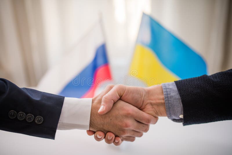 The representatives of Ukraine and Russia shaking hands, Ukraine peace agreement concept.