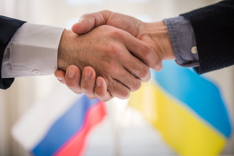 The representatives of Ukraine and Russia shaking hands, Ukraine peace agreement concept.