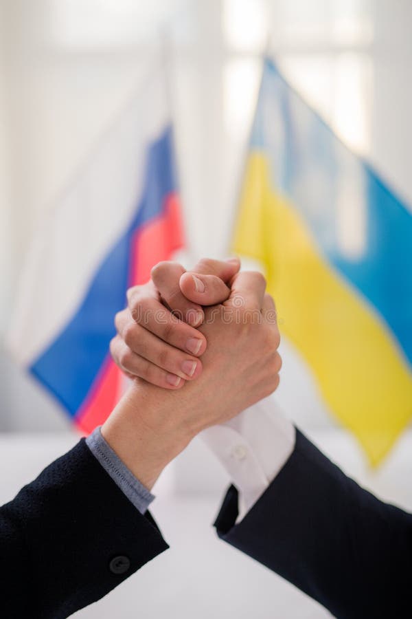 The representatives of Ukraine and Russia shaking hands, Ukraine peace agreement concept.