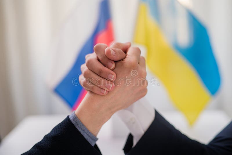 The representatives of Ukraine and Russia shaking hands, Ukraine peace agreement concept.