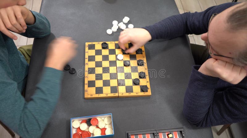Reproducir cheques. Niño adolescente jugando al juego de mesa con su padre. . Agitar las manos almacen de video
