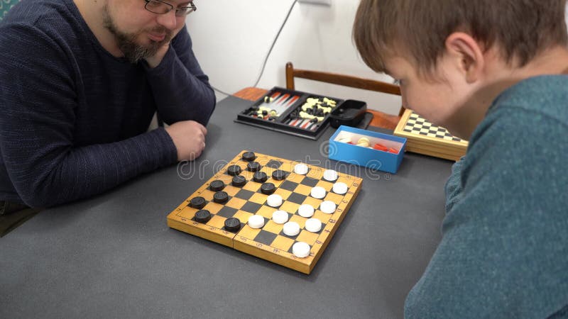 Reproducir cheques. Niño adolescente jugando al juego de mesa con su padre. Tiempo de familia metrajes