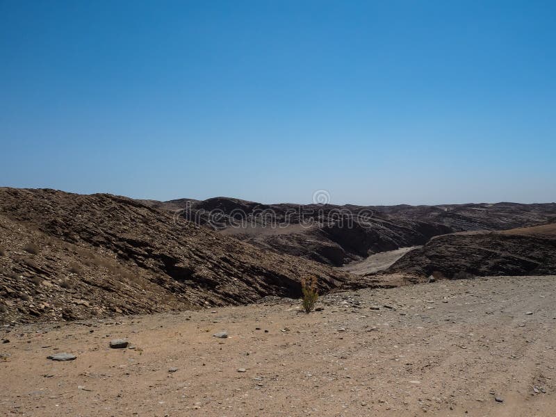 Resan till och med utmärkt vaggar bakgrund för bergtexturlandskapet av unik geografi för den Namib öknen med blixtrande stenjordn arkivbild Resan till och med utmärkt vaggar bakgrund för bergtexturlandskapet av unik geografi för den Namib öknen med blixtrande stenjordn arkivbild