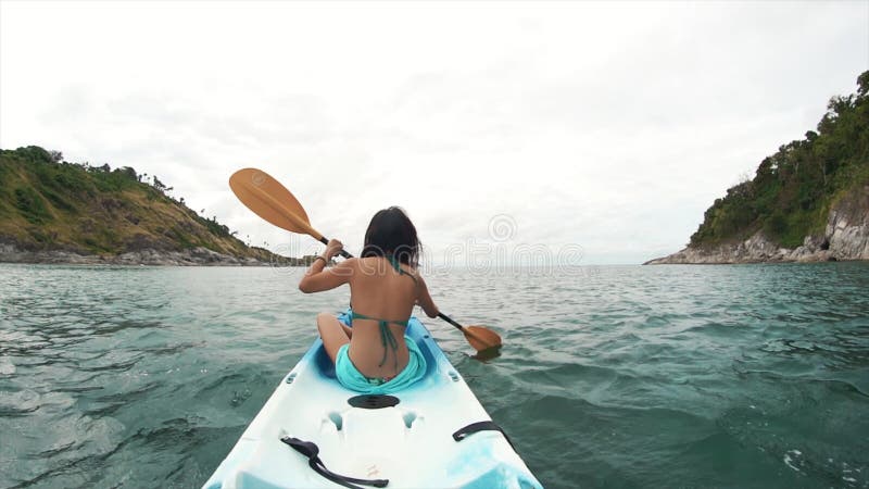 Resande kvinna som roterar i en kayak. turism och rekreation i Thailand. charmig, söt asiatisk kvinna reser runt på öarna stock video