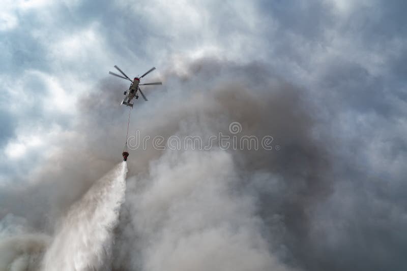 Rescue helicopter drops water extinguishes fire stock photo