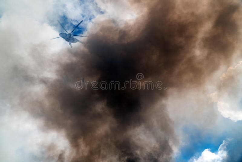 Rescue helicopter drops water extinguishes the fire royalty free stock image