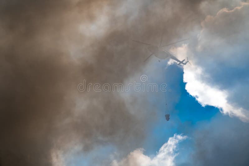 Rescue helicopter drops water extinguishes the fire royalty free stock photography