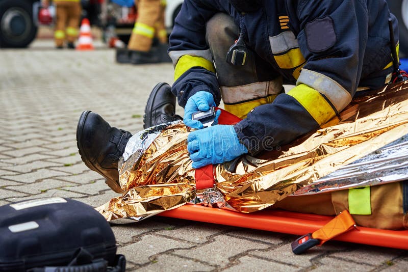 Rescuers provide first aid to the victim during a car accident. Person injured in the accident is lying on the road. Rescuers provide first aid to the victim during a car accident. Person injured in the accident is lying on the road
