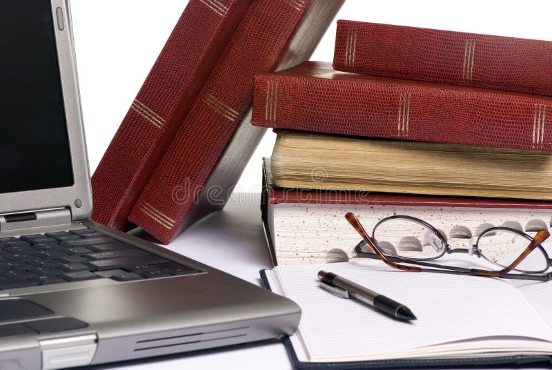 Research paper. Books are strewd across a table, as somebody is doing research for an assignment paper Research paper. Books are strewd across a table, as somebody is doing research for an assignment paper