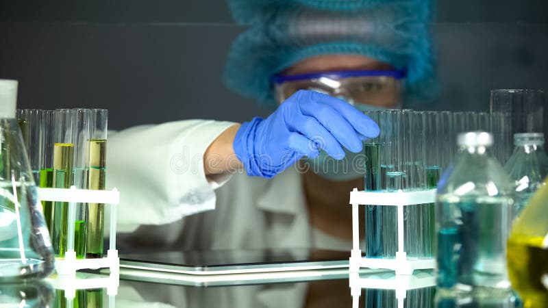 Researcher taking tube with blue liquid, scientific researches, quality control royalty free stock photography Researcher taking tube with blue liquid, scientific researches, quality control royalty free stock photography