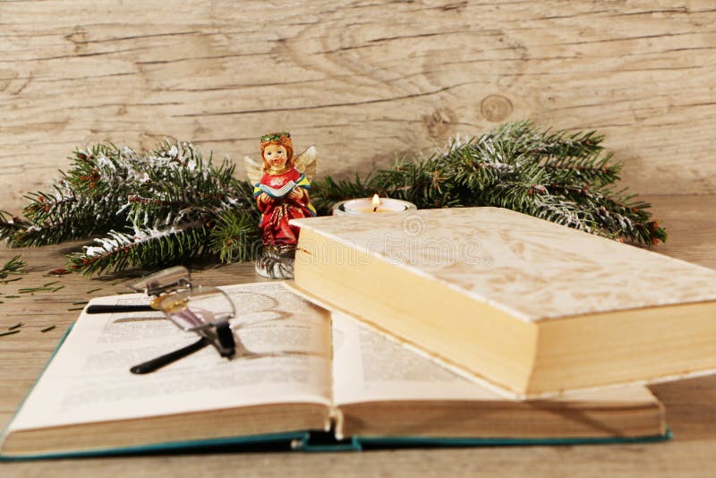 Reservar y quemar velas en una mesa de madera. leyendo un libro de navidad. preparación para exámenes de secundaria. estudio de materiales científicos en la biblioteca
