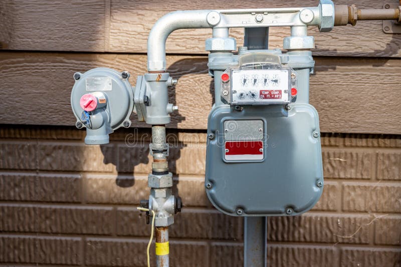 Residential gas meter and pressure regulator. Setup from gas line to residential house with meter visible