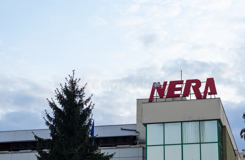 Resita, Romania - March 29, 2021: Nera Shopping Center photographed on the blue sky next to a towering Christmas tree in the city