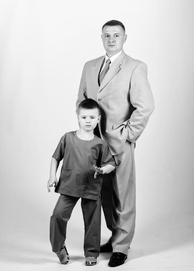 Respectable profession. Man respectable businessman and little kid doctor uniform. Family business. Doctor respectable.