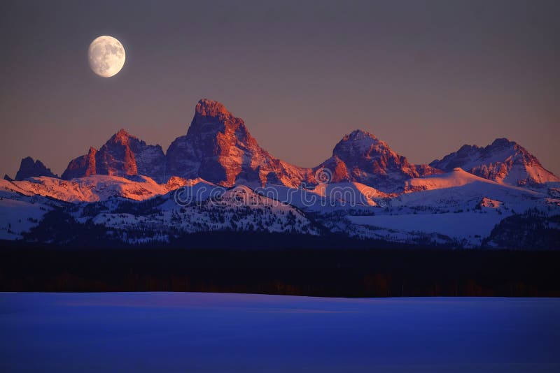 Resplandor de Alpen de la luz de la puesta del sol en las montañas de Tetons Teton con el levantamiento de la luna fotografía de archivo Resplandor de Alpen de la luz de la puesta del sol en las montañas de Tetons Teton con el levantamiento de la luna fotografía de archivo