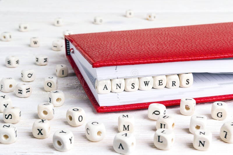 Respostas da palavra escritas em blocos de madeira no caderno vermelho em w branco imagem de stock Respostas da palavra escritas em blocos de madeira no caderno vermelho em w branco imagem de stock