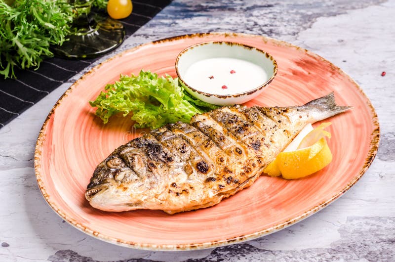Restauranger - hela grillade dorado med citronskivor och gröna bönor på platter, restaurangbord Den översta vyn har bakats fotografering för bildbyråer Restauranger - hela grillade dorado med citronskivor och gröna bönor på platter, restaurangbord Den översta vyn har bakats fotografering för bildbyråer