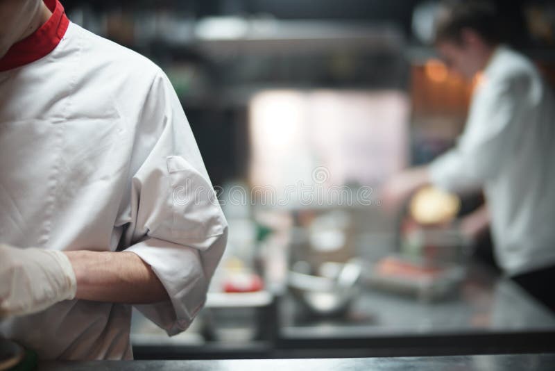 Restaurant Chef Cook Preparing Salmon Filet Flambe in Open Kitchen