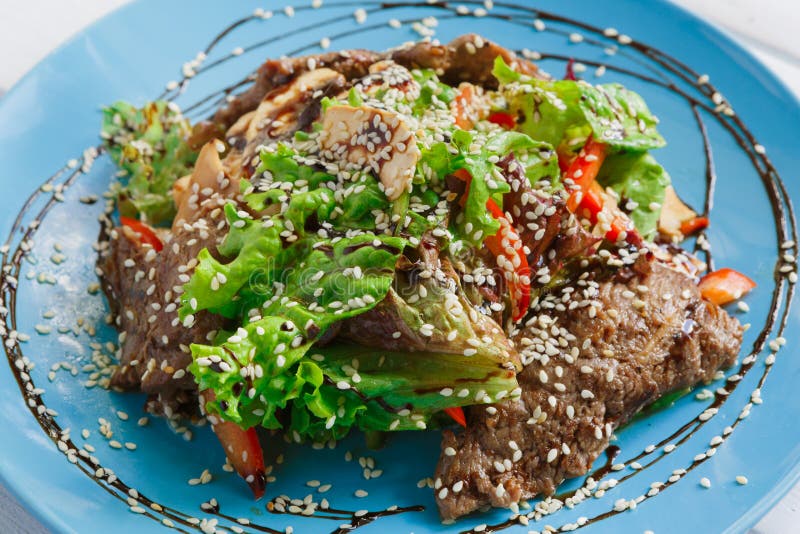 Restaurant food closeup. Warm meat salad with sesame