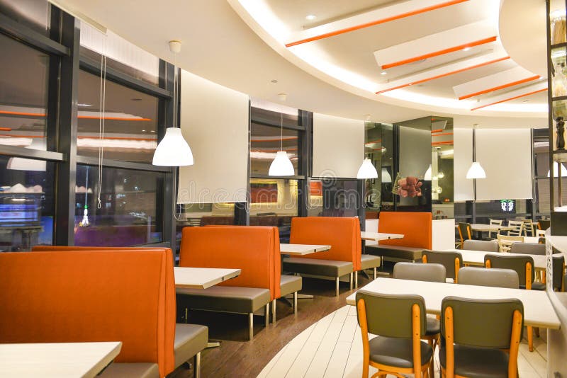 Restaurant interior eating house ,design with white wooden tables ,beige and orange chairs,ceiling lighting. Restaurant interior eating house ,design with white wooden tables ,beige and orange chairs,ceiling lighting