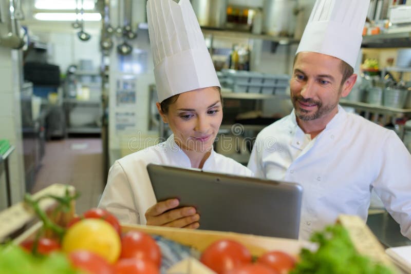 Restaurant manager showing tablet to chef stock photography