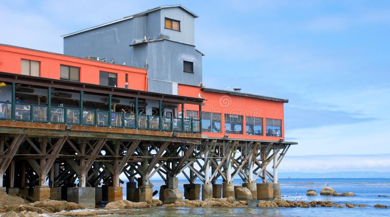 A restaurant sitting on a large wooden pier along the coast in Monterey California. Red pylons stock images, royalty-free photos and pictures