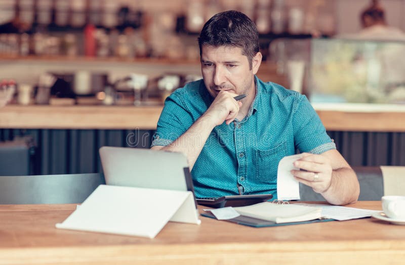 Restaurant owner checking monthly reports on a tablet, bills and expenses of his small business. Start-up entrepreneur concerned stock images Restaurant owner checking monthly reports on a tablet, bills and expenses of his small business. Start-up entrepreneur concerned stock images