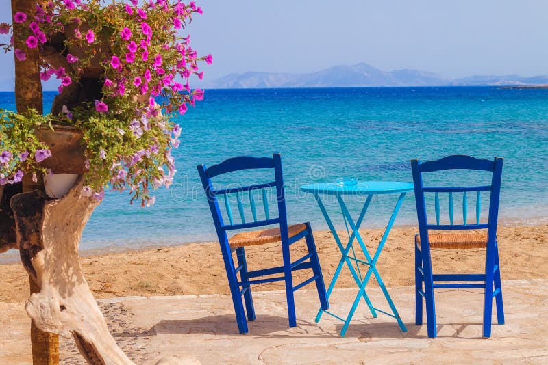 Restaurant table and chairs with a relaxing view of Moutsouna beach, Naxos island stock photos Restaurant table and chairs with a relaxing view of Moutsouna beach, Naxos island stock photos