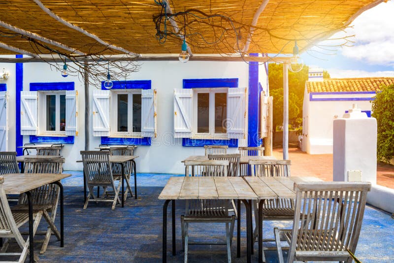 Restaurant tables with chairs on terrace near Praia da Rocha beach on coast of Portimao, Algarve, Portugal. Tables on terrace in royalty free stock image Restaurant tables with chairs on terrace near Praia da Rocha beach on coast of Portimao, Algarve, Portugal. Tables on terrace in royalty free stock image