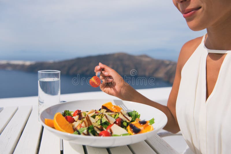 Restaurant woman eating salad luxury europe travel Santorini vacation. Healthy lifestyle people relaxing on Greece