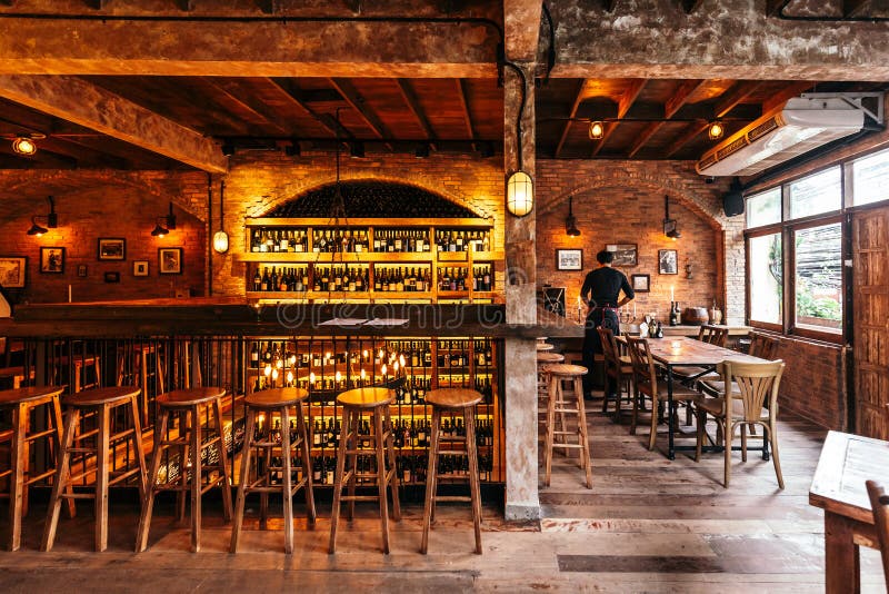 Restaurante italiano adornado con el ladrillo en la luz caliente que creó la atmósfera acogedora con el camarero en la tabla dere fotos de archivo libres de regalías Restaurante italiano adornado con el ladrillo en la luz caliente que creó la atmósfera acogedora con el camarero en la tabla dere fotos de archivo libres de regalías