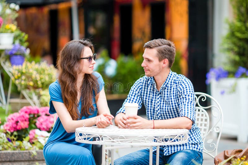 Restauranttoeristen die bij openluchtkoffie eten De jonge vrienden genieten samen van tijd in de zomerdag stock foto Restauranttoeristen die bij openluchtkoffie eten De jonge vrienden genieten samen van tijd in de zomerdag stock foto