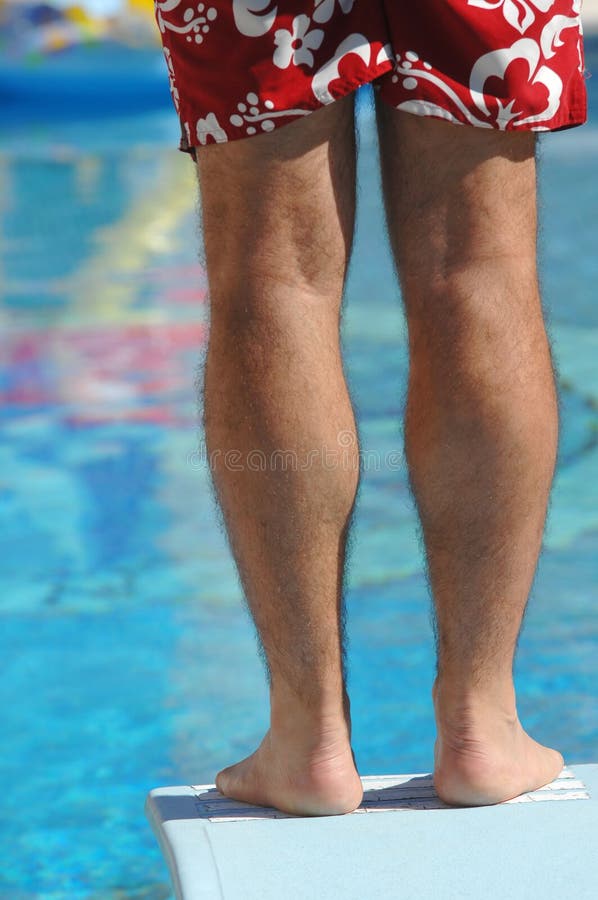 Standing on the end of a diving board at a swimming pool. Standing on the end of a diving board at a swimming pool