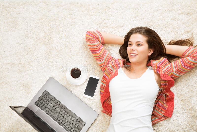 Resting Woman with Laptop Phone Coffee Cup, Beautiful Girl Top View Lying Down on Back on White Carpet Floor. Background stock images Resting Woman with Laptop Phone Coffee Cup, Beautiful Girl Top View Lying Down on Back on White Carpet Floor. Background stock images