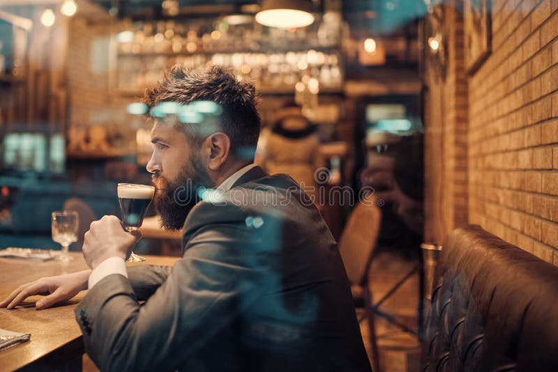 Resto barbudo del hombre en restaurante con el vidrio de cerveza Hombre de negocios con la bebida larga de la barba en club del c fotos de archivo Resto barbudo del hombre en restaurante con el vidrio de cerveza Hombre de negocios con la bebida larga de la barba en club del c fotos de archivo