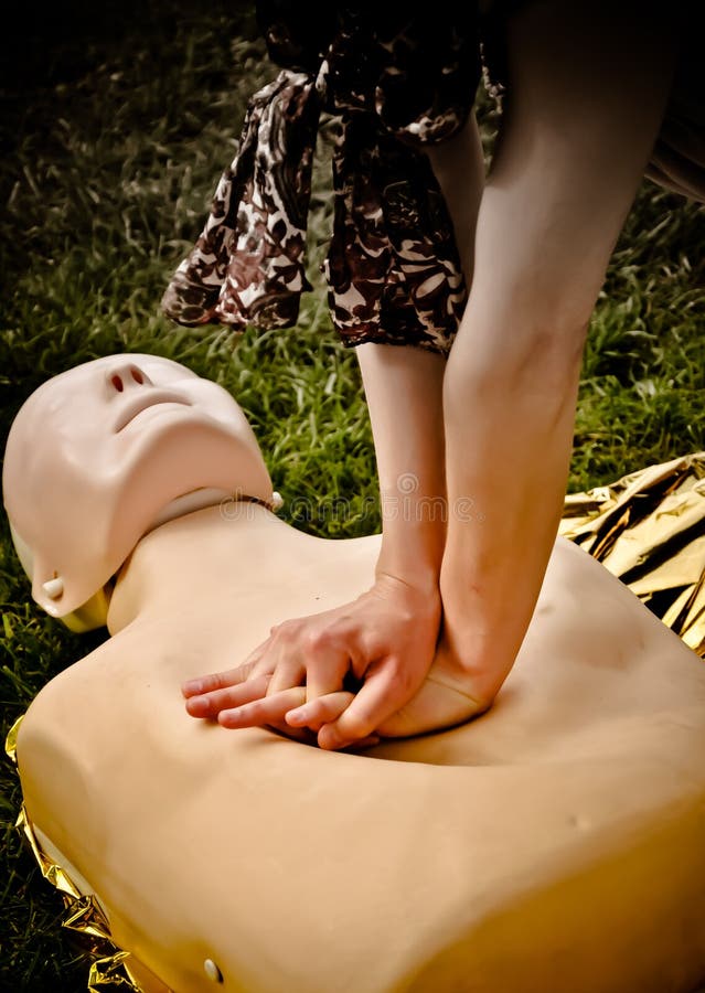 Woman practising CPR methods on dummy. Woman practising CPR methods on dummy