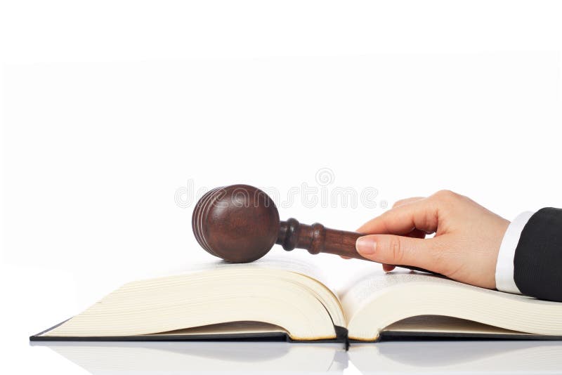 Retenir un marteau en bois au-dessus du livre de loi images stock