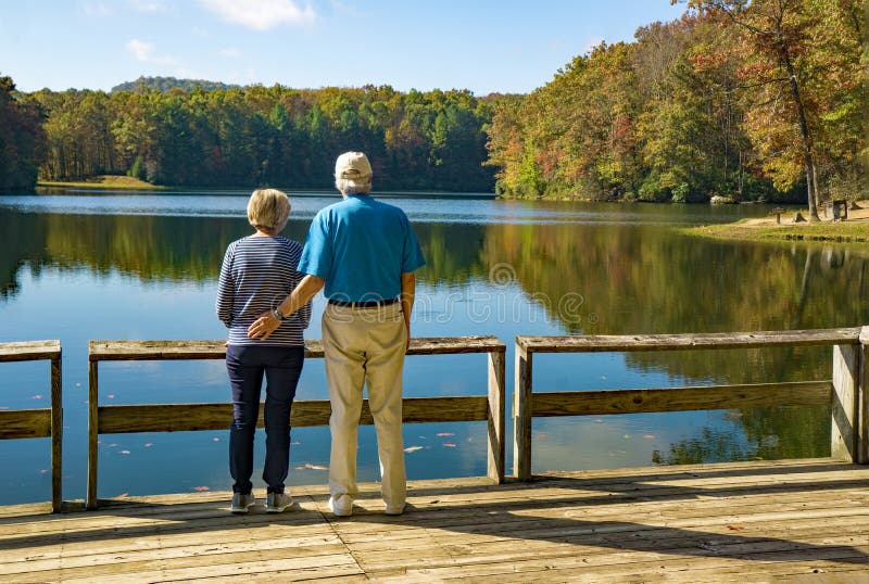 Retired Couple at Boley Lake, West Virginia, USA. Clifftop, WVA – October 12th: A retired couple on a pier enjoying the view of Boley Lake located in Babcock stock images Retired Couple at Boley Lake, West Virginia, USA. Clifftop, WVA – October 12th: A retired couple on a pier enjoying the view of Boley Lake located in Babcock stock images