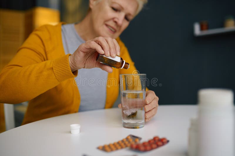 Retired elderly woman dripping medical sedative drops