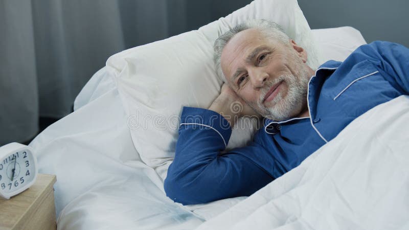 Retired man waking up active and full of energy after comfortable healthy sleep