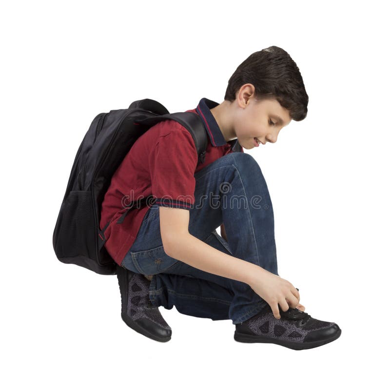 Retour à l'école - Portrait d'un garçon d'école qui attache des lacets de chaussures image libre de droits