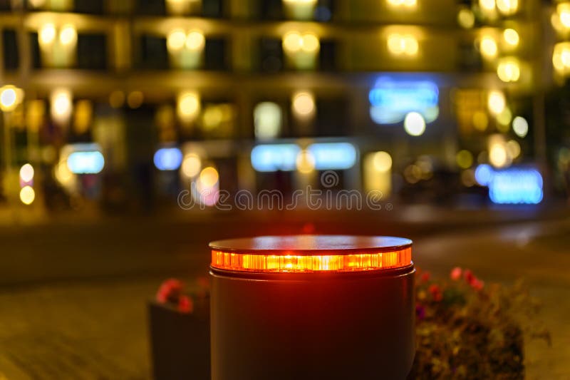 A retractable bollard with a red warning light as a barrier to a pedestrian area at night in Bansin, Germany.