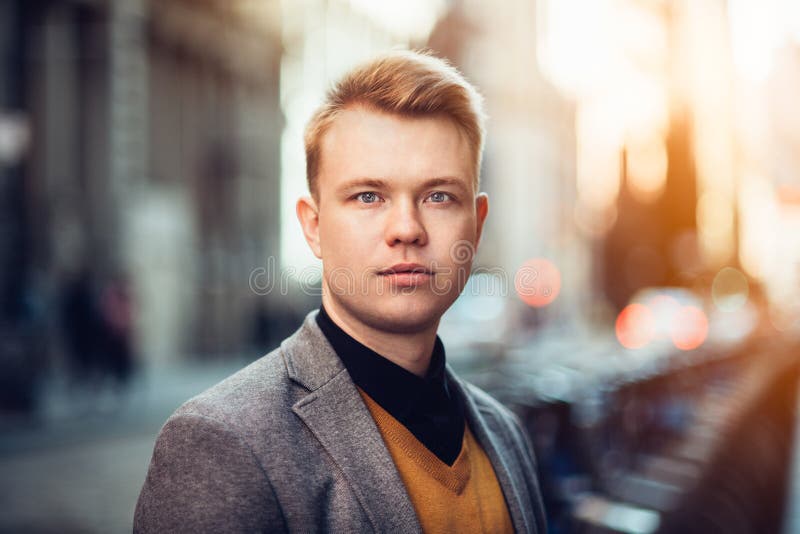 Retrato adulto joven hermoso del hombre de negocios al aire libre en la calle de la ciudad en el tiempo de la puesta del sol foto de archivo libre de regalías Retrato adulto joven hermoso del hombre de negocios al aire libre en la calle de la ciudad en el tiempo de la puesta del sol foto de archivo libre de regalías