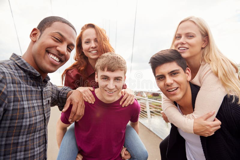 Retrato Al Aire Libre De Estudiantes Amigos Con Hombres Dando Caminatas A Mujeres En Piggyback imagenes de archivo