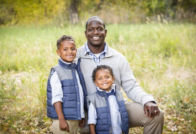 Retrato al aire libre de un padre racial diverso con sus dos hijos imágenes de archivo libres de regalías Retrato al aire libre de un padre racial diverso con sus dos hijos imágenes de archivo libres de regalías