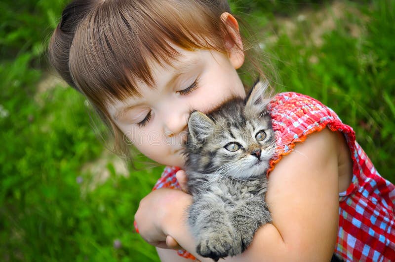 Outdoor portrait of cute little girl with small kitten, girl playing with cat on natural background. Outdoor portrait of cute little girl with small kitten, girl playing with cat on natural background